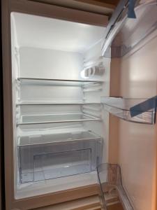 einem leeren Kühlschrank mit offener Tür und leeren Regalen in der Unterkunft Apartment 19 near Metro & Netflix in Wien