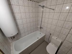 a bathroom with a bath tub and a toilet at Апартамент Извор 6 in Smolyan