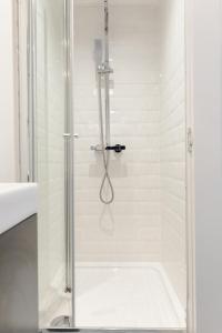 a shower with a glass door in a bathroom at Bay City Studio Apartments in Cardiff