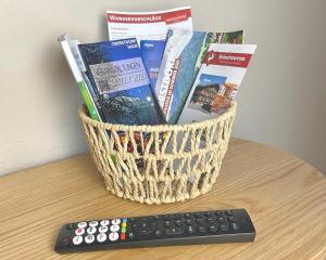 un cesto di libri e un telecomando su un tavolo di Ferienwohnung Tiefenbach mit Garten a Oberstdorf