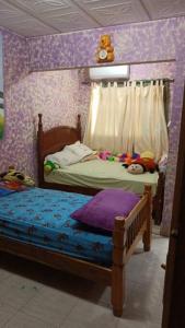 1 Schlafzimmer mit 2 Betten und einer lila Wand in der Unterkunft Casa en Las Tablas in Las Tablas