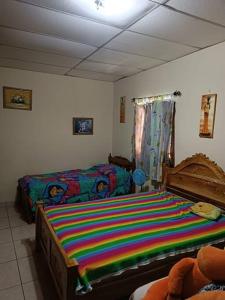 um quarto com uma cama com um cobertor listrado colorido em Casa en Las Tablas em Las Tablas