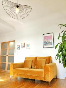 ein braunes Sofa im Wohnzimmer mit einer Decke in der Unterkunft HYPERCENTRE - Calme et lumineux. AufildeLorient in Lorient