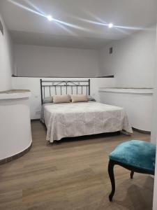 um quarto com uma cama e um banco azul em Villa Urbina em Olerdola