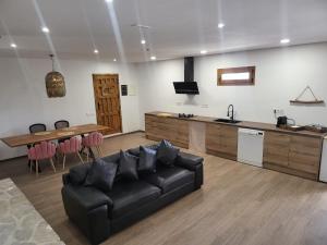 uma sala de estar com um sofá preto e uma mesa em Villa Urbina em Olerdola