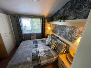 sypialnia z dużym łóżkiem i poduszkami w obiekcie Golden Palm Resort - Carnival - Coastal Caravan Breaks w mieście Chapel St Leonards +12 zdjęć