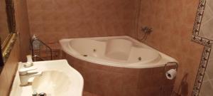 a bathroom with a tub and a white sink at La casa de Angelita in Trelew +1 photo