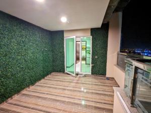 een kamer met groene muren en een glazen deur bij DHA Phase 4 Gold Crest Mall One Bedroom Serviced Apartment in Lahore