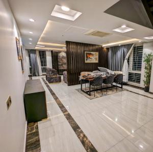 een woonkamer met een tafel en stoelen bij DHA Phase 4 Gold Crest Mall One Bedroom Serviced Apartment in Lahore