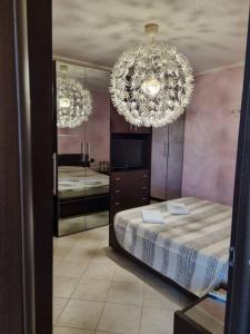 ein Schlafzimmer mit einem Bett und einem großen Kronleuchter in der Unterkunft bilocale nel cuore della toscana in Montopoli in Val dʼArno