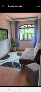 sala de estar con sofá y alfombra en Aconchego no bairro mais charmoso da serra. en Nova Friburgo