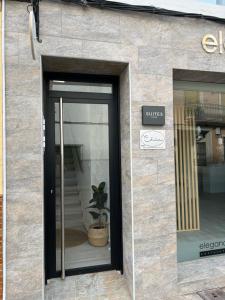 a store front with a door with a potted plant at Suites Chic Cozy in Herencia