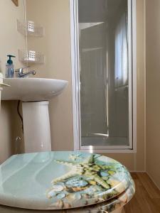 baño con lavabo y mesa de cristal en Stacaravan Middelkerke en Middelkerke