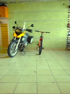 a yellow motorcycle parked in a room next to a bike at Caicai Bed And Breakfast in Saluzzo