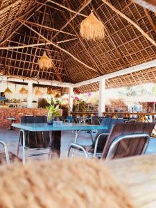 a restaurant with blue tables and chairs and ceilings at Malik Villa Matemwe in Ndizi