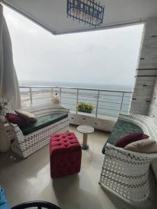 een balkon met een bad en stoelen en een tafel bij شقه فاخره على الكورنيش in Alexandrië