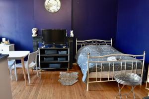 1 dormitorio con cama, mesa y TV en La Domus Lemaitre 5- Parking - TV - Wifi 