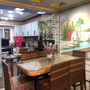 a kitchen with a table with chairs and a painting at شقه فاخره على الكورنيش in Alexandria