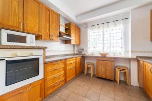 a large kitchen with wooden cabinets and counters at Trendy Homes Toyo Golf in Almería
