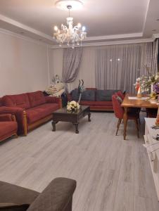a living room with red couches and a chandelier at Yalova in Çiftlikköy