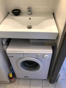 a white washing machine under a counter with a sink at Appartement vue mer les pieds dans l'eau in Collioure