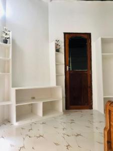 Pokój z białymi ścianami i drewnianymi drzwiami w obiekcie Malik Villa Matemwe w mieście Ndizi