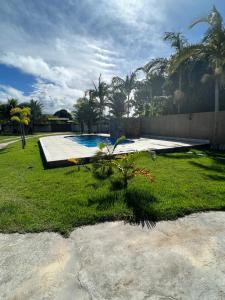 a yard with a swimming pool and a fence at CasAmarela in Santa Cruz Cabrália