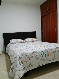 a bed with a white comforter and a wooden cabinet at NEW COZY APARTMENT 101 IN MEDELLIN, ENVIGADO in Envigado