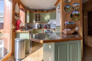 una cucina con mobili verdi e un piano di lavoro di Chalet King's Hame a Méribel