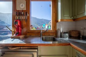una cucina con un lavandino e una finestra di Chalet King's Hame a Méribel