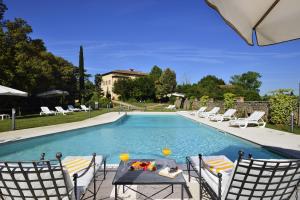 una piscina con sillas y una mesa con una comida. en Villa Sabolini en Colle Val D'Elsa