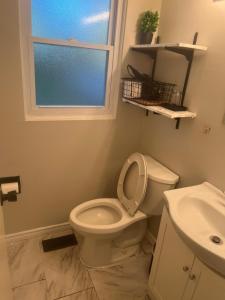 La salle de bains est pourvue de toilettes, d'un lavabo et d'une fenêtre. dans l'établissement Choose, 1of 2 entire! appart- 1BR-1sofa bed king size-free prkg- at Mohawk college city of falls, à Hamilton