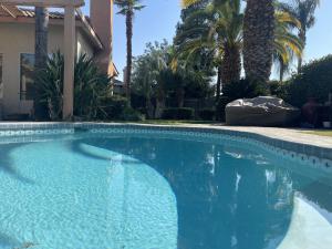 basen przed domem z palmami w obiekcie Spirit Lake Luxury Poolside Escape! w mieście Bakersfield