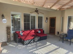 parawan na ganku z czerwoną kanapą na patio w obiekcie Spirit Lake Luxury Poolside Escape! w mieście Bakersfield