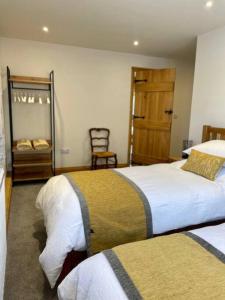 um quarto de hotel com duas camas e um espelho em The Old Dairy. A beautifully converted barn with stunning views em Charlecote