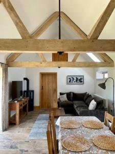 uma sala de estar com uma mesa e um sofá em The Old Dairy. A beautifully converted barn with stunning views em Charlecote