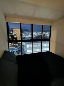 a bedroom with a large window with a view of a city at Súper depa con vista al mar in Acapulco