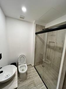 a bathroom with a toilet and a glass shower at Súper depa con vista al mar in Acapulco