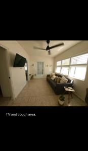 - un salon avec un canapé et un ventilateur de plafond dans l'établissement Boater House PR, à Salinas