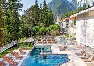 un hotel con piscina, sillas y montañas de fondo en Appartamento Nel Verde, en Bracca