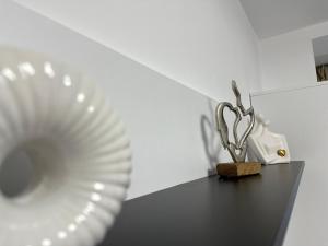 Un plato blanco y una estatua de un par de tijeras. en XOX Comfort Obregia, en Bucarest 6 fotos más