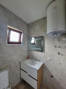 La salle de bains est pourvue d'un lavabo, d'un miroir et de toilettes. dans l'établissement Eleon Motel, à Brezovicë
