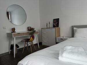 Un dormitorio con una cama, un escritorio y un espejo. en XOX Comfort Obregia, en Bucarest