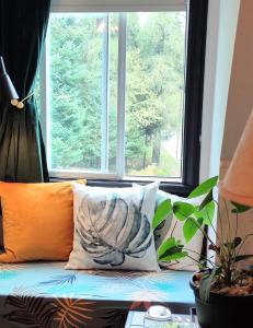 - un canapé avec des oreillers en face d'une fenêtre dans l'établissement La Tremblante, à Mont-Tremblant