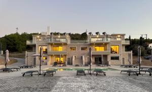 un gran edificio con una piscina frente a él en Topos luxury stay Heraion en Loutraki
