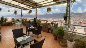 a patio with tables and chairs and a view of a city at Hotel-Apartment INKASABIOS in Cusco