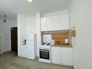 a white kitchen with a stove and a refrigerator at Klea’s Apartaments in Pristina