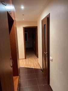 een hal die leidt naar een kamer met een deur en een hal bij Dainai Apartments in Šiauliai