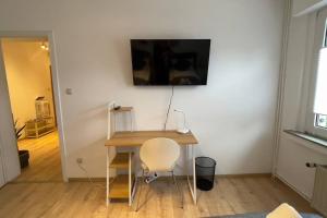 a table with a chair and a television on a wall at Apartment FeWo54 FreeWifi, Free Parking, SmartTV in Hamm