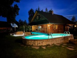 a swimming pool in front of a house at night at Zacisze Pod Lipą in Andrychów